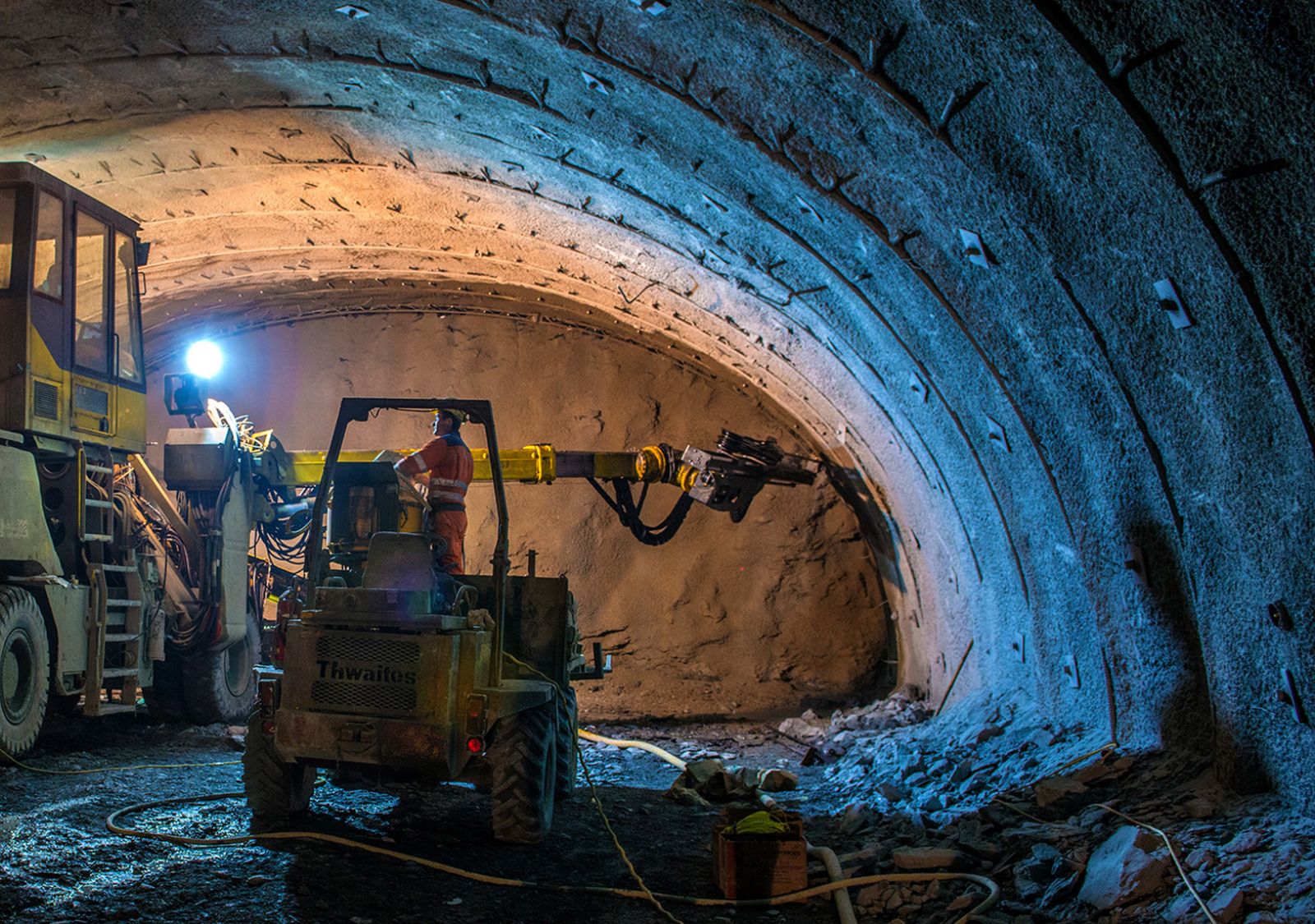 Ingenieure graben in einem Tunnel mit großen Werkzeugen.